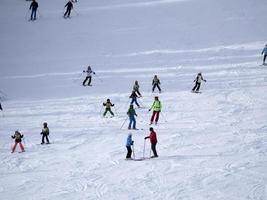 de nombreux skieurs skiant dans les montagnes de neige de la vallée de Gardena dolomites photo