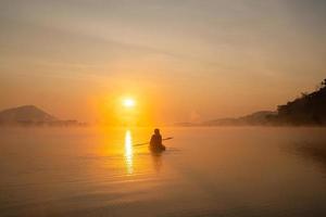 femmes sur des lignes de kayak dans le réservoir pendant le lever du soleil, parc forestier de harirak huai nam man réservoir loei thaïlande 21 janvier 2023 photo