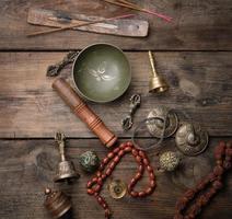 bol chantant en cuivre, chapelet, tambour de prière et autres objets religieux tibétains pour la méditation et la médecine alternative photo