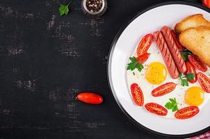 Anglais petit déjeuner - frit œuf, tomates, saucisse, et toasts. Haut voir, aérien photo