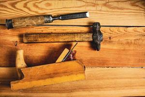 ensemble de outils pour menuisiers, marteau, ciseau et avion sur en bois Contexte. photo