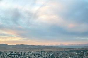 scénique vue sur tbilissi ville paysage urbain à crépuscule avec magnifique le coucher du soleil plus de le collines. photo