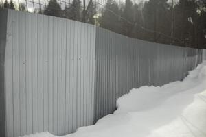 clôture dans neige. territoire est clôturé. métal profil. photo