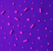 Créatif plat allonger Haut vue de pilules et capsules sur une violet Contexte. traitement et de espérer pour récupération. minimal concept modèle pour en ligne pharmacie. photo