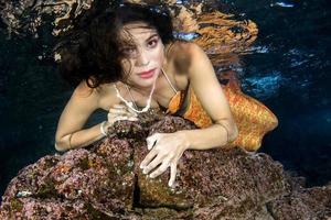 sirène nageant sous l'eau dans la mer d'un bleu profond photo