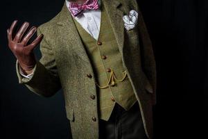 portrait de gentleman en costume de tweed et gants de cuir debout divinement. concept de gentleman britannique classique et excentrique photo