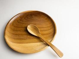 proche en haut en bois assiette et cuillère isolé sur blanc Contexte. choisi concentrer photo