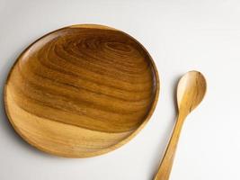 proche en haut en bois assiette et cuillère isolé sur blanc Contexte. choisi concentrer photo