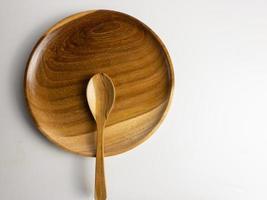 proche en haut en bois assiette et cuillère isolé sur blanc Contexte. choisi concentrer photo