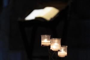 Bougies votives à l'intérieur d'une église isolée sur fond noir photo