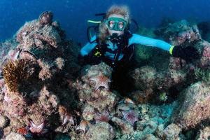 beauté blond plongeur fille à la recherche à vous avec rouge mer étoiles photo