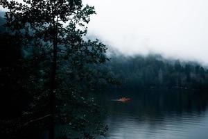 bateau orange dans un lac brumeux photo