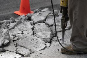 homme travaillant avec un marteau-piqueur sur la route photo