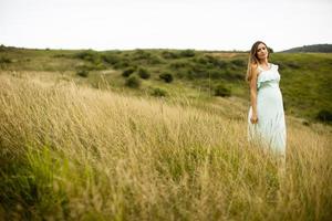 jeune femme enceinte se détendre à l'extérieur dans la nature photo