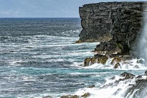 mer dans la tempête vagues déferlantes sur la falaise de roche de lave photo