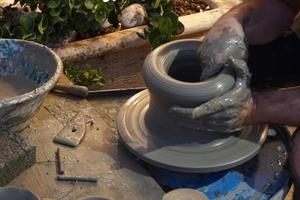 Mains travaillant sur le détail de gros plan de poterie photo