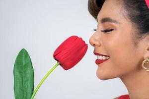Portrait d'une belle femme avec des fleurs de tulipes rouges