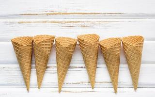 Cornets de crème glacée sur fond de bois blanc photo