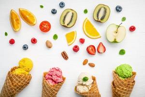 Fruits frais et cornets de crème glacée sur fond blanc photo