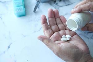 La main de l'homme senior avec des médicaments renversés du contenant de pilules