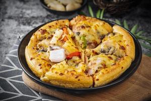 classique Pizza avec fromage sur le table dans une café sur une en bois supporter avec une Couper triangulaire pièce et une Pizza couteau photo