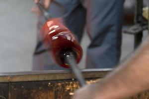 maître verrier tout en travaillant dans l'usine de verre de four de murano venise italie photo