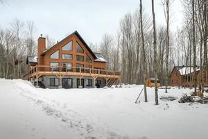 hiver chalets dans éloigné zone Québec, Canada, Journal maison avec sauna, spa, chambres à coucher, piscine, vivant chambre, messanine, cuisine et salles de bain photo