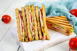 club sandwich avec jambon, tomate, vert et fromage. grillé panini photo