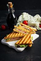 club sandwich avec jambon, tomate, vert et fromage. grillé panini photo