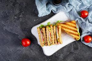 club sandwich avec jambon, tomate, vert et fromage. grillé panini. Haut vue photo