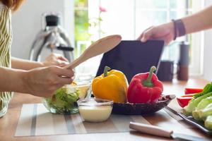 Jeune femme en train de préparer cloche poivre comme une petit déjeuner ingrédient et prêt pour en bonne santé cuisine et sur le table là sont des légumes cette sont en bonne santé biologique ingrédients. en bonne santé nourriture préparation des idées photo