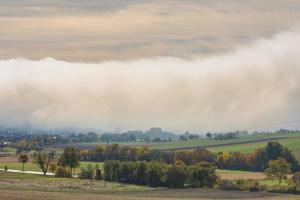 énorme mur de blanc brouillard plus de une village dans le la nature paysage détail photo