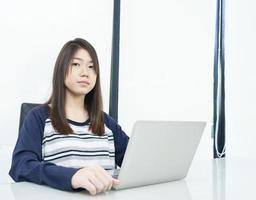 jeune étudiante assise dans le salon et apprenant en ligne photo