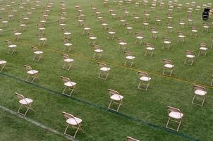 Rangées de chaises pliantes sur pelouse verte