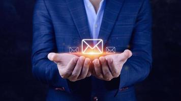 homme d'affaires détenant la vérification des e-mails en ligne avec la technologie d'interface virtuelle. marketing direct, message en ligne, e-mail, courrier électronique, concept de communication. photo