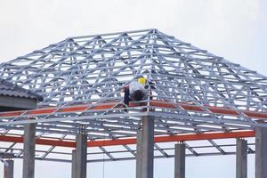 construction de une maison avec une épais acier Cadre et toiture carrelage pour Soleil et pluie protection par qualifié artisans qui travail à hauteurs a besoin précision et extrême mise en garde - Espagnol style - photo