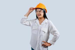Jeune femelle ingénieur portant Jaune casque supporter avec charmant sourire posture photo