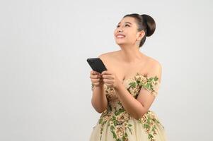 jeune belle mariée asiatique affichant avec un smartphone à la main photo