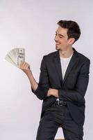 Portrait d'un homme gai tenant des billets d'un dollar sur fond blanc photo