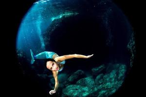 sirène nageant sous l'eau dans la mer d'un bleu profond photo