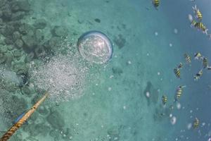 bulles de plongeur près de corde de bateau sous l'eau photo