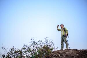 promeneur homme permanent sur Haut de Montagne ou falaise et à la recherche sur vallée photo