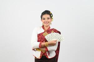 portrait de magnifique thaïlandais femme dans traditionnel Vêtements posant avec ventilateur billet de banque photo