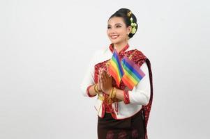 portrait de Jeune femme dans thaïlandais nord-est traditionnel Vêtements en portant arc en ciel drapeau photo