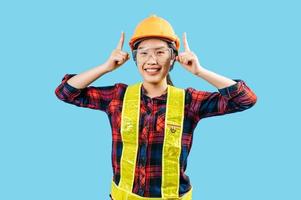 Jeune femelle ingénieur portant Jaune casque avec point doigt posture photo