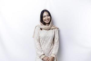 Jeune asiatique musulman femme portant hijab souriant à le caméra, isolé par blanc Contexte photo