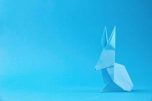 papier origami Pâques lapin sur une bleu Contexte. Pâques fête concept photo