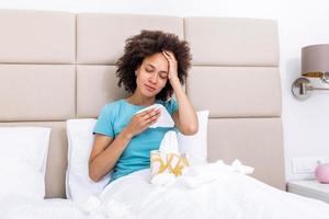 jour de maladie à la maison. la jeune femme a un rhume qui coule et commun. toux. gros plan d'une belle jeune femme attrapée par le rhume ou la grippe. portrait d'une fille malsaine avec coronavirus, symptômes covid19 photo