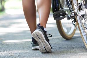 jambes de jeune femme en forme faisant du vélo dans un parc de la ville photo