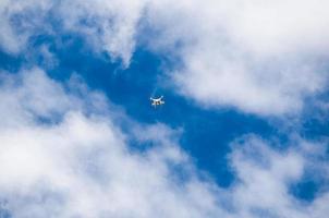petit drone en volant dans le nuageux ciel. photo